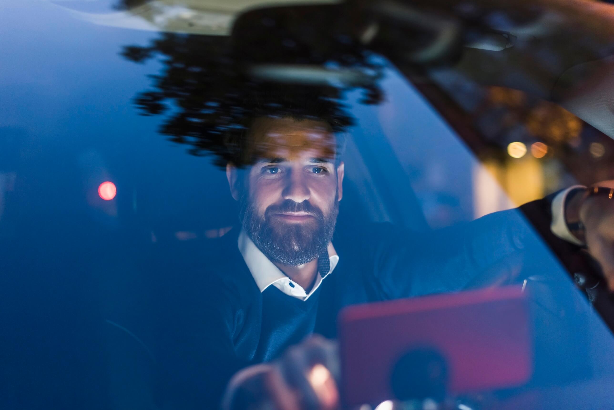 Businessman using navigation device in car at night