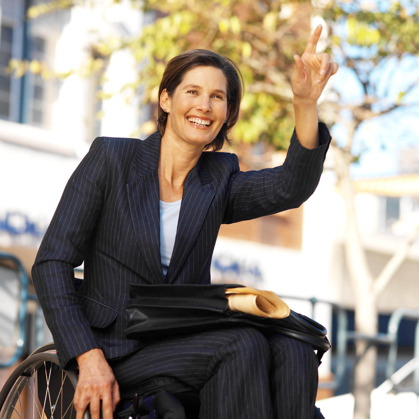 Businesswoman in a wheelchair hailing a taxi